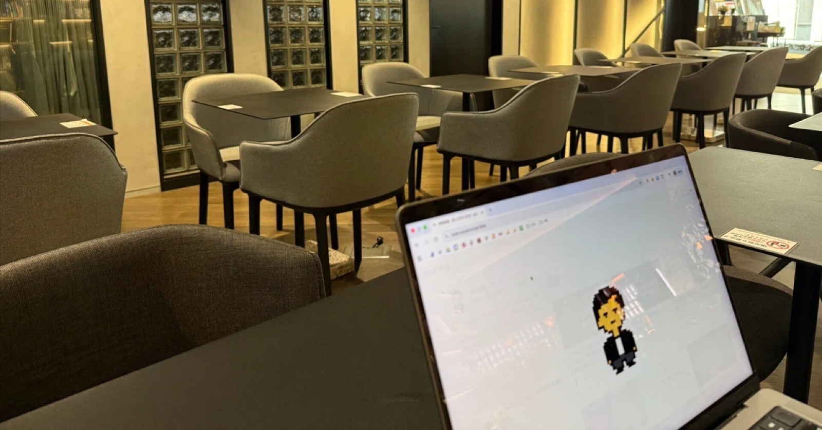 2026年4月24日 早朝の新宿、朝活1on1壁打ちの会場ラウンジ。ノートPCに岸田佳祐のドット絵アバターが表示されている